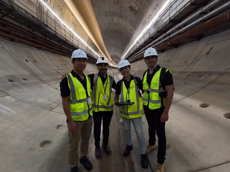 The iottag team in hi-vis vests and hard hats standing inside a segment-lined tunnel