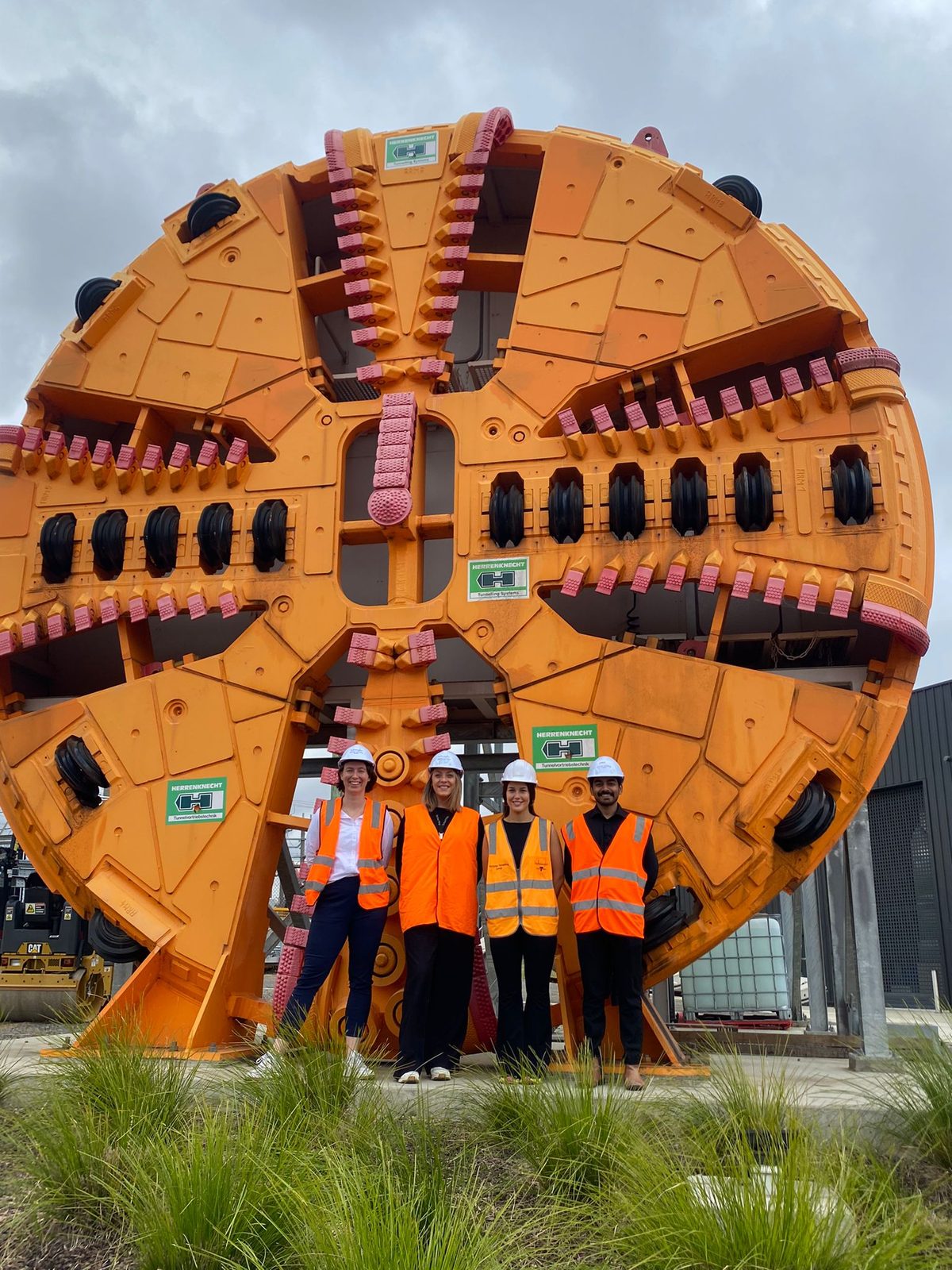 The iottag team standing in front of a tunnel boring machine cutterhead