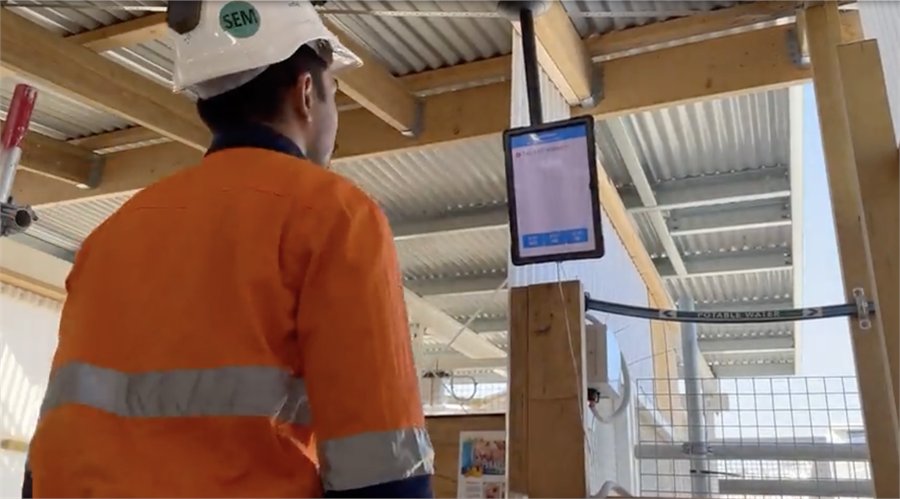 Worker in high-visibility clothing using a mounted tablet on site