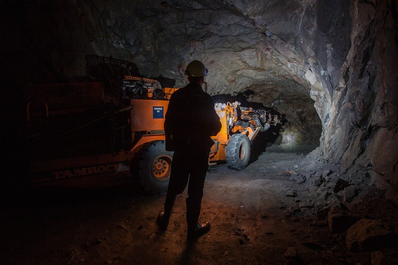 Miner watching a drill rig working an underground decline