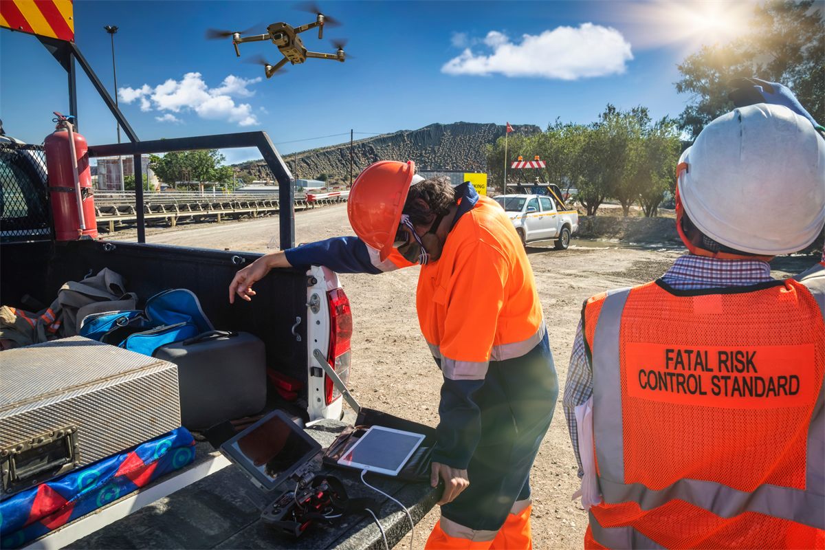 Fatal risk control station operator reviewing drone and tablet data at a vehicle tailgate