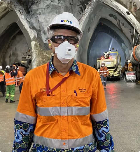 Site engineer wearing a respirator mask inside a tunnel excavation